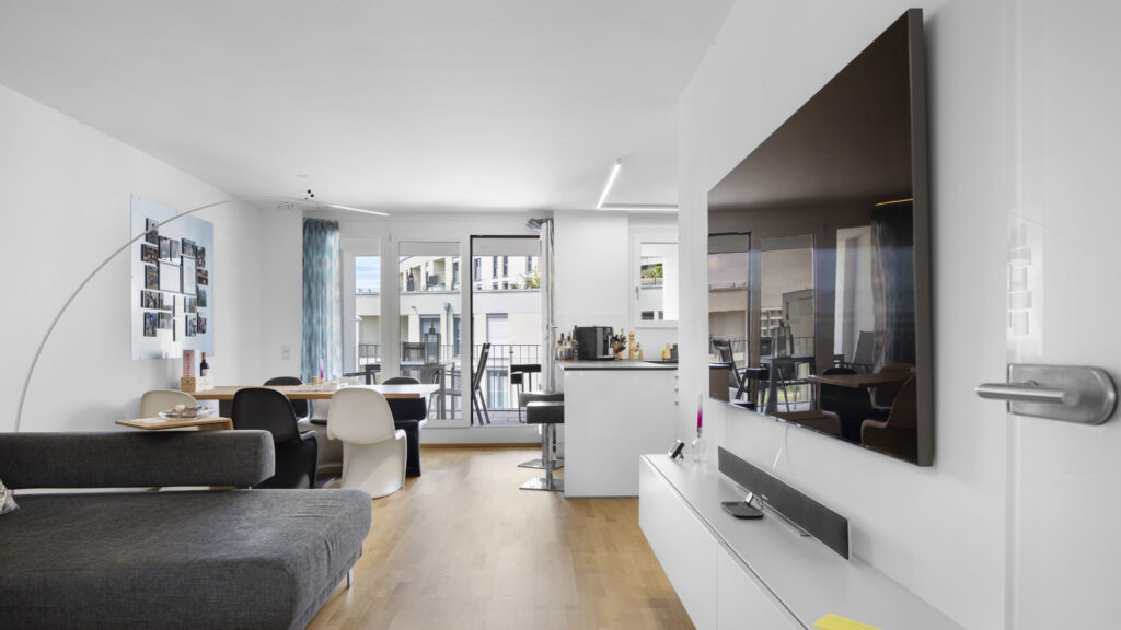 Living room with seating area and view of the open kitchen in a condominium in Munich-Aubing