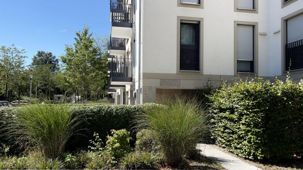 Facade detail with hedges and planting of a residential building in Munich-Berg am Laim