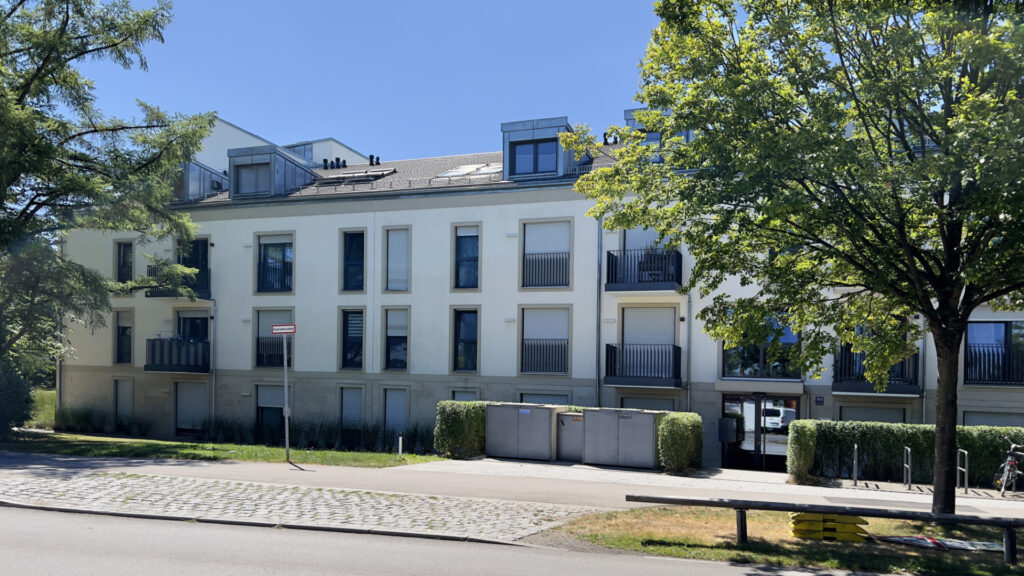 Street view of a modern residential building with trees in Munich-Berg am Laim
