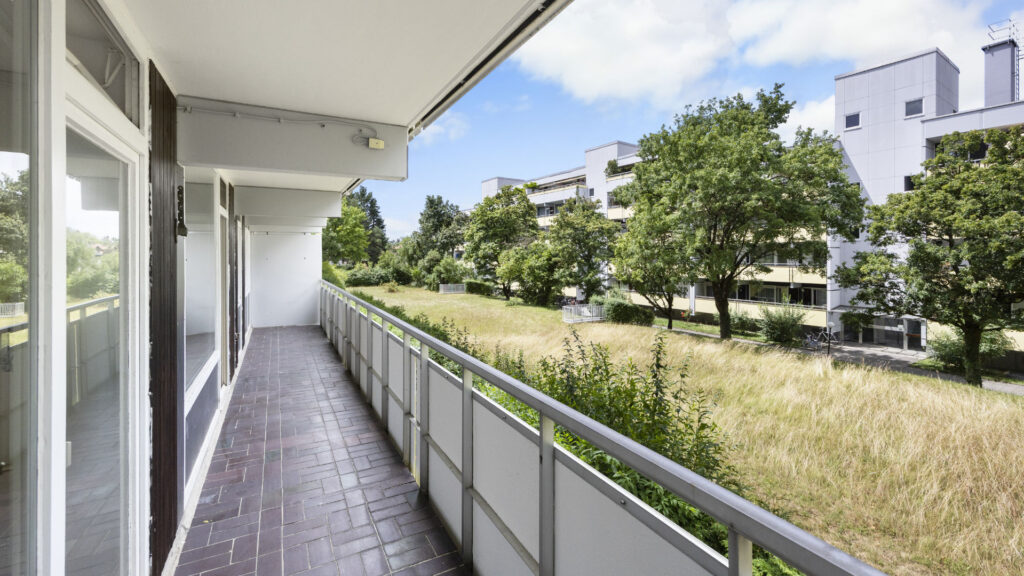 Long arcade-style balcony with a view of meadow and trees in Berg am Laim