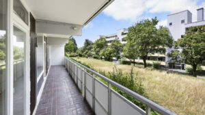 Long arcade-style balcony with a view of meadow and trees in Berg am Laim