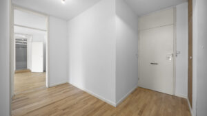 Empty hallway with wooden floor and multiple doors in a condominium in Munich-Berg am Laim