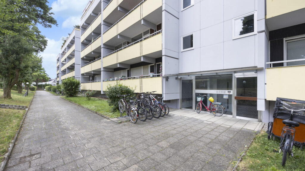 Entrance with bicycles and glass door at residential building in Munich-Berg am Laim