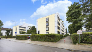 Paved access path to the yellow-and-white residential building in Munich Berg am Laim