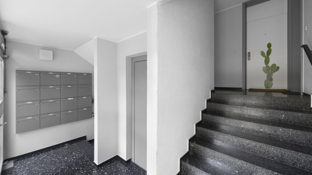 Stairwell with mailboxes and terrazzo flooring in the Berg am Laim condominium building
