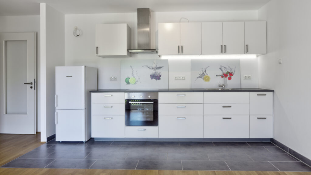 Kitchenette with extractor hood and refrigerator in an apartment in Munich-Berg am Laim
