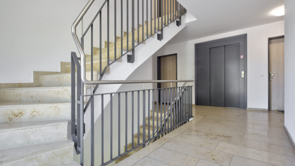 Modern staircase with marble floor and elevator in a new building in Munich-Berg am Laim