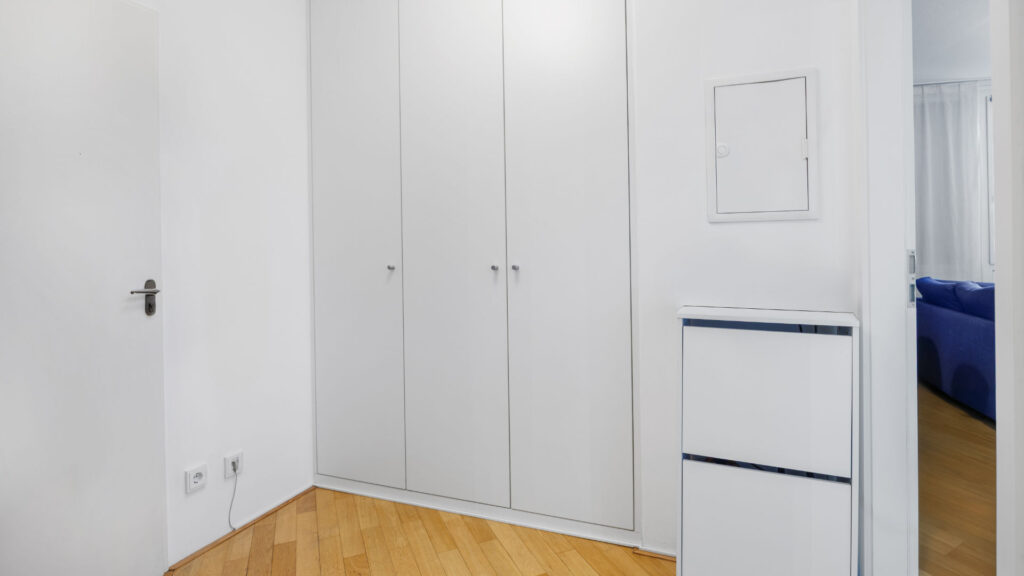 Hall with white built-in cabinet and parquet floor in a condominium in Munich-Bogenhausen