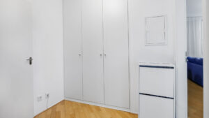Diele mit weißem Einbauschrank und Parkettboden in einer Eigentumswohnung in München-Bogenhausen