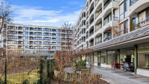 Gebäudeansicht mit Balkonen und Eingangsbereich vom Innenhof aus, Wohnung in München-Bogenhausen