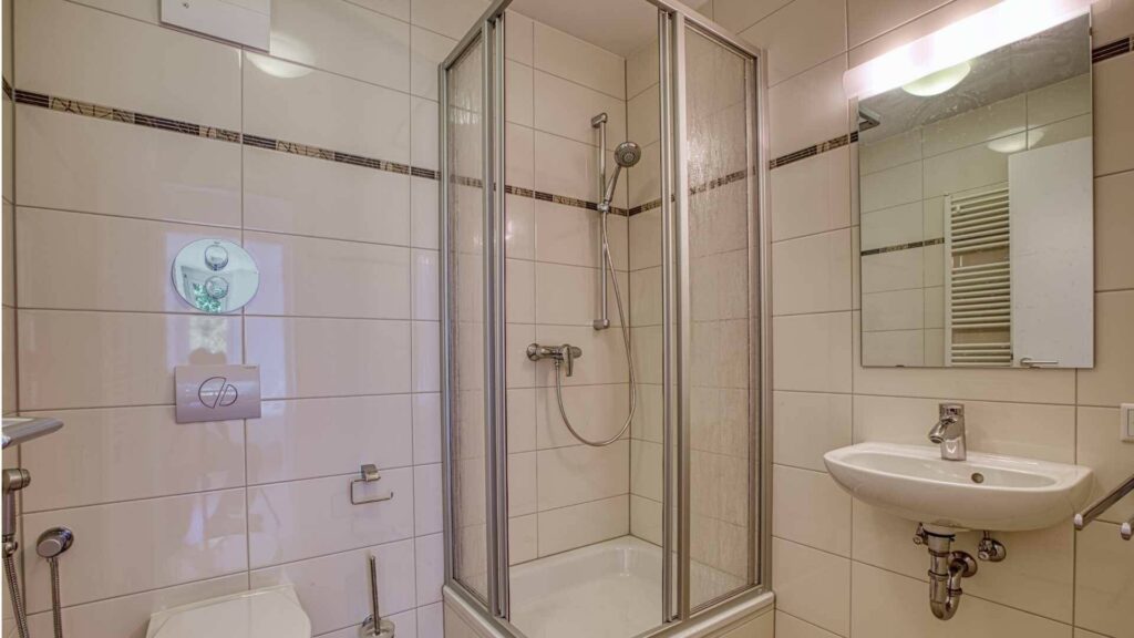 Badezimmer der Mietwohnung in Bogenhausen mit Duschkabine, WC und Waschbecken