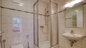 Badezimmer der Mietwohnung in Bogenhausen mit Duschkabine, WC und Waschbecken