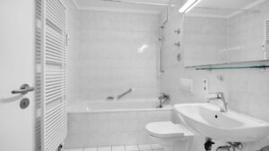 Tiled bathroom with bathtub, toilet and sink in a rented apartment in Munich-Bogenhausen
