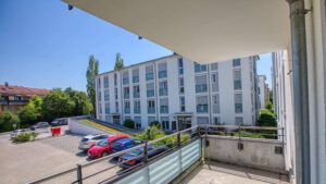 Balkon der Mietwohnung in Bogenhausen mit Blick auf das Nachbargebäude und Parkplatz