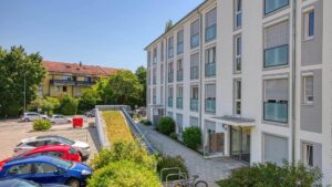 Blick aus dem Fenster der Mietwohnung in Bogenhausen auf Parkplatz und Nachbargebäude