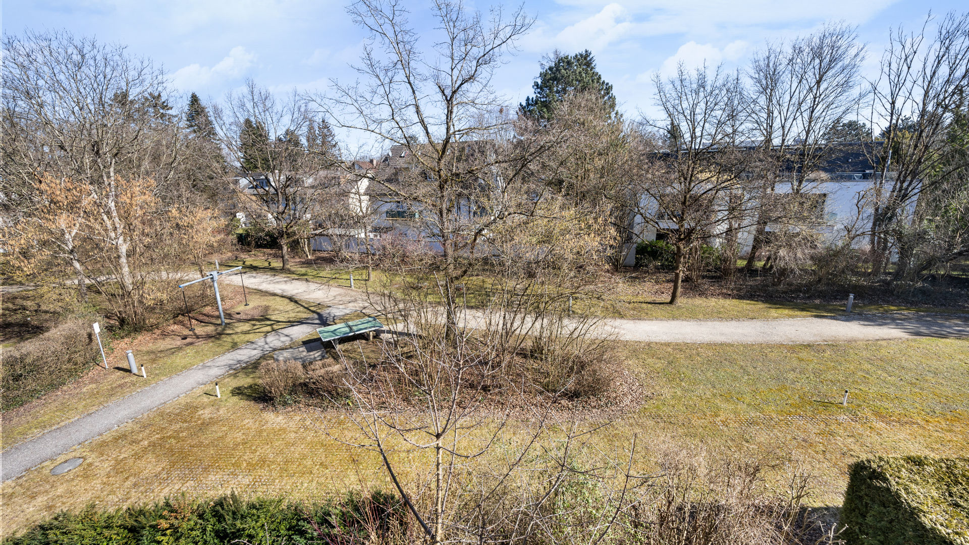 View from the balcony of a park path with a parked car and trees, Bogenhausen