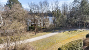 View from the balcony of a path, green space, and body of water in the distance, Bogenhausen