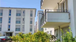 Fassadenansicht des Wohngebäudes in Bogenhausen mit Balkon und begrüntem Vorgarten