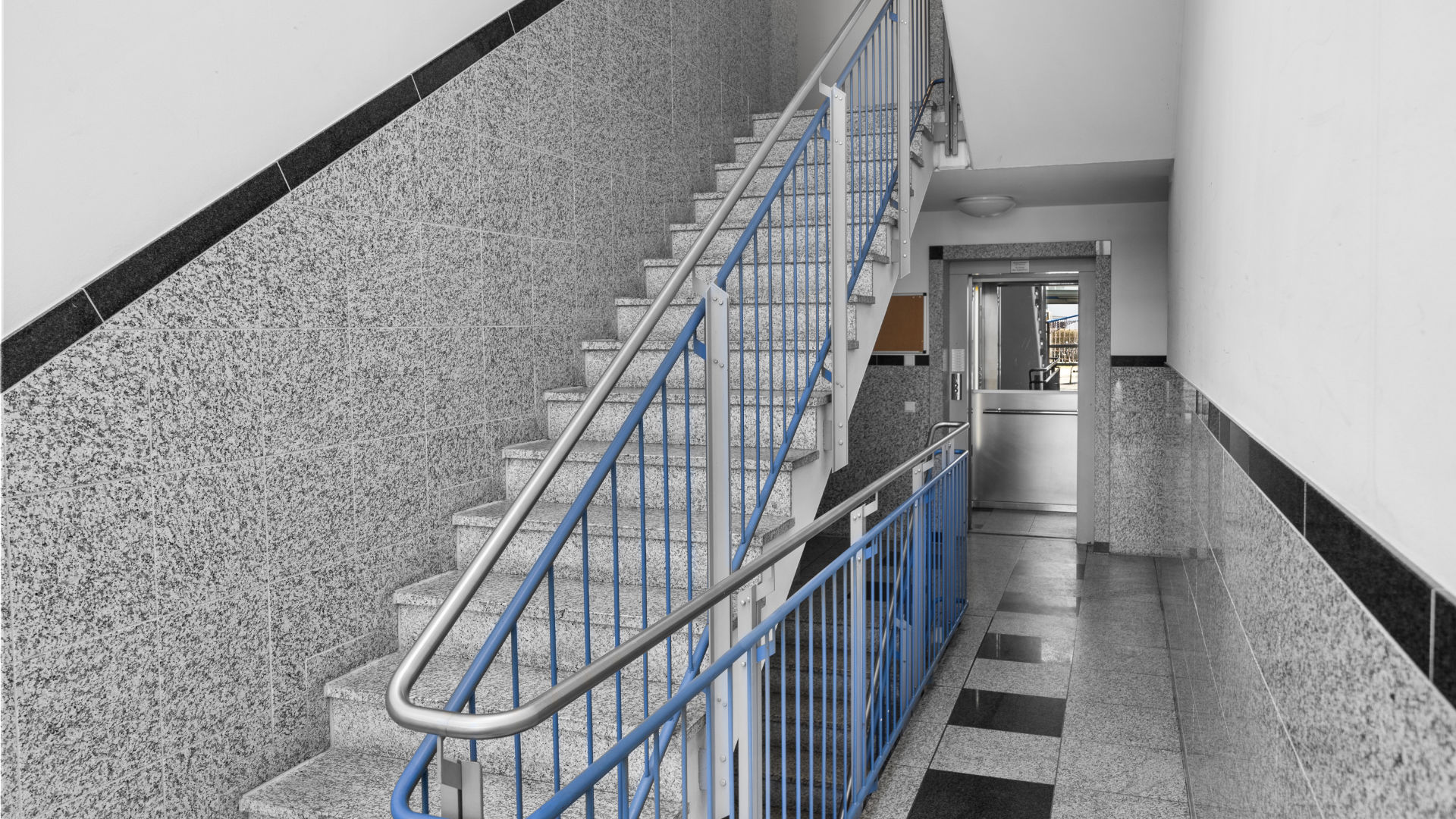 Stairwell with blue railing and granite cladding in the Bogenhausen apartment building