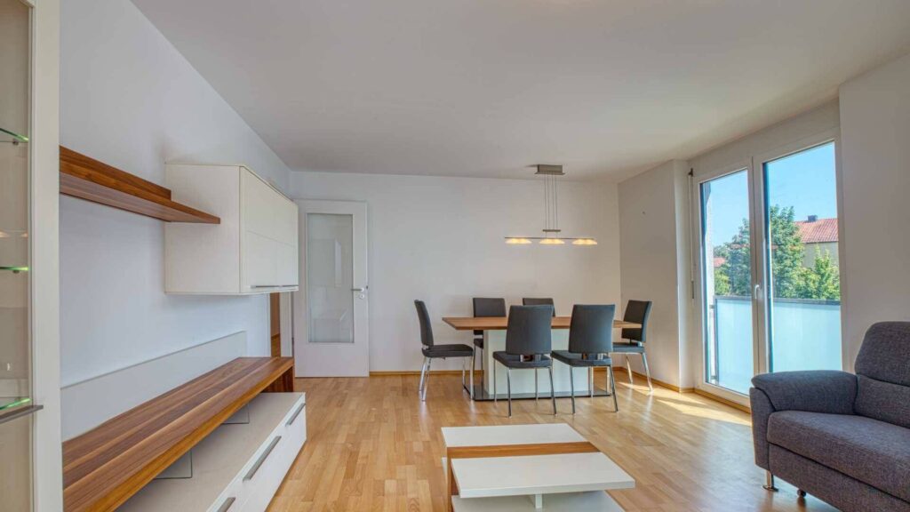 Wohnzimmer der Mietwohnung in Bogenhausen mit Essbereich, Sitzecke und Terrassenzugang