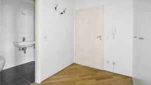 Diele mit Blick auf ein Gäste-WC und helle Zimmertür in einer Wohnung in München-Bogenhausen