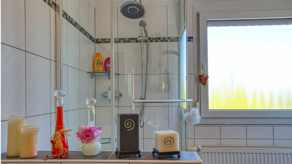 Bestehendes Badezimmer mit Dusche, Fliesen und Fenster im Haus in München-Feldmoching
