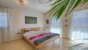 Schlafzimmer mit Doppelbett und großen Fenstern im Haus in München-Feldmoching