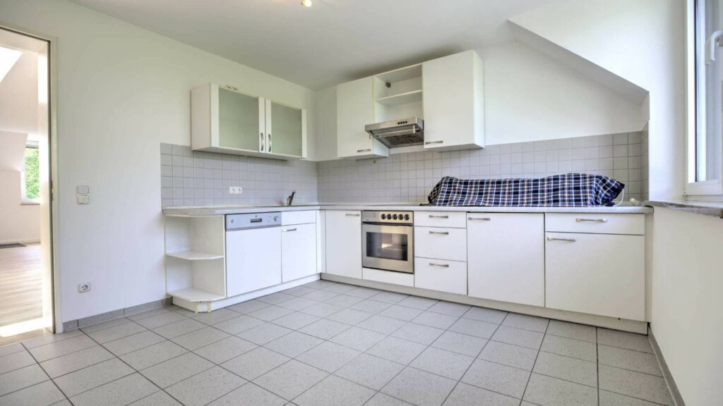 Weiße Einbauküche mit Fliesenboden in einem Büroobjekt in München-Fürstenried.