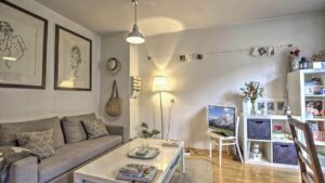 Wohnzimmer mit grauem Sofa und Bilderwand in einer Wohnung im Gärtnerplatzviertel München