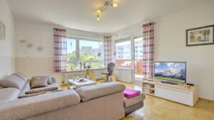 Wohnzimmer mit beiger Couch und Panoramafenster in einer Wohnung in Germering