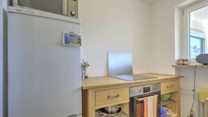 Kompakte Küchenzeile mit Kühlschrank und Fenster in einer Wohnung in Germering