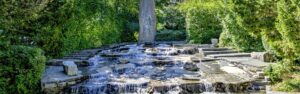 Naturnaher Wasserlauf mit Steinen in einer parkähnlichen Anlage in Germering