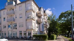 Historische Hausfassade mit Balkonen und Erkern eines Mehrfamilienhauses in München-Giesing bei blauem Himmel