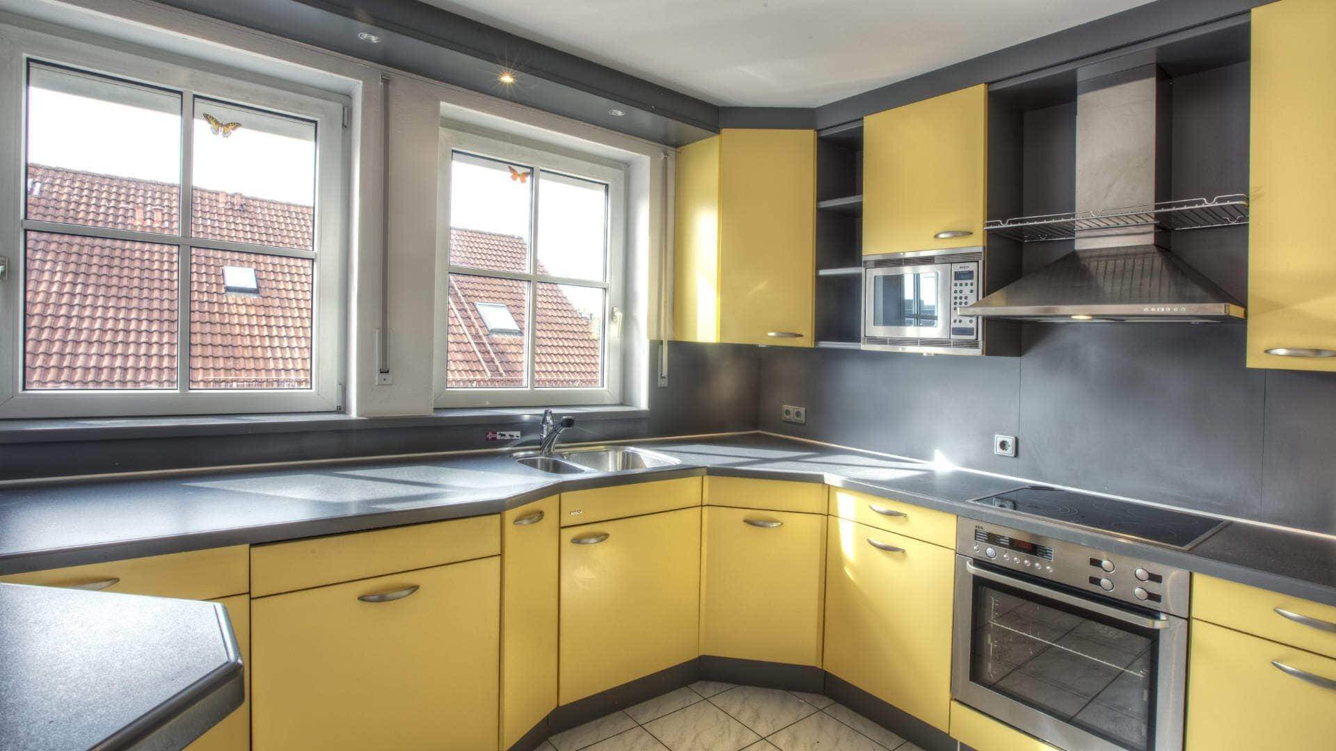 Gelbe Einbauküche mit Dachfenstern in einer Dachgeschosswohnung in Gilching