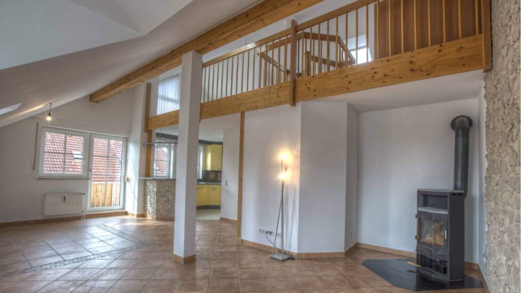 Offenes Wohnzimmer mit Galerie, Kaminofen und hohen Decken in einer Wohnung in Gilching