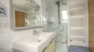 Badezimmer mit Dusche, Waschbecken und Handtuchheizkörper in einer Wohnung in Gilching