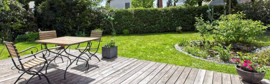 Wooden terrace with garden furniture and lawn area of a single-family house in Munich-Großhadern