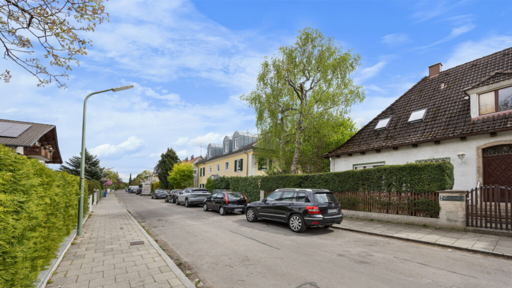 Residential street near the property in Großhadern with trees, hedges, and parked vehicles