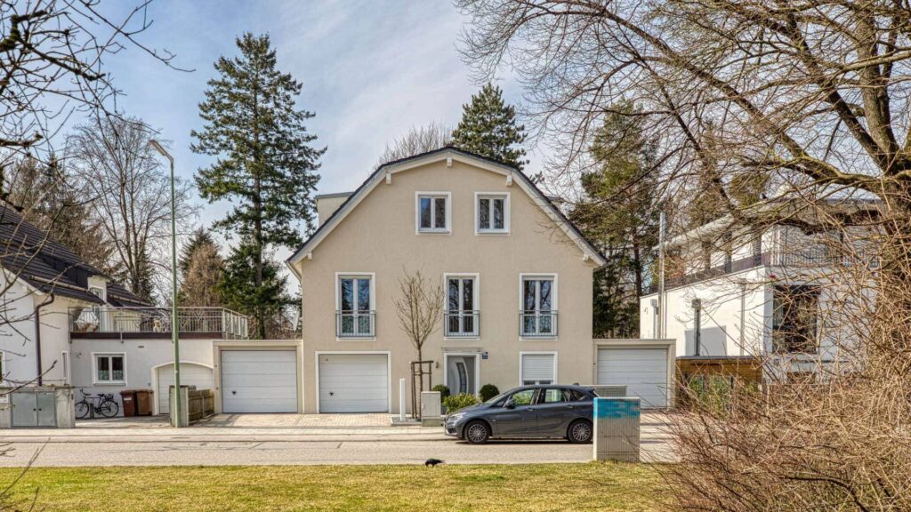 Mehrfamilienhaus mit Satteldach und Bäumen an der Straßenseite in München-Hadern