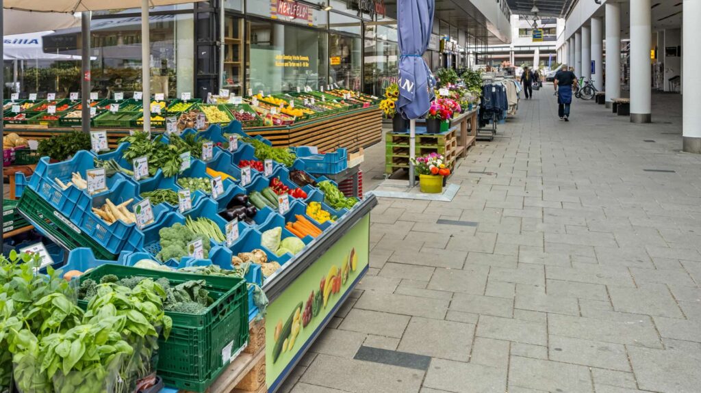 Market stall with fresh fruit and vegetables in the shopping arcade near the apartment in Hadern