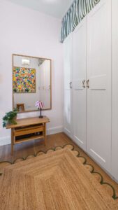 Dressing room of the old building apartment in Haidhausen with white closets, wall mirror and colorful art print