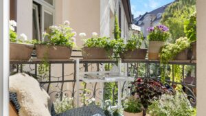 Balcony of the old building apartment in Haidhausen with flower boxes on the railing and a view over the Munich rooftops
