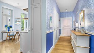 Transition from the blue wallpapered hallway to the open kitchen in the Haidhausen old-style apartment
