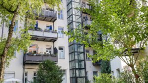 Rear view of an old building with balconies behind trees in Munich-Haidhausen