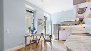 Kitchen with a dining area at the bay window and a view toward the kitchenette in a classic Haidhausen old building apartment