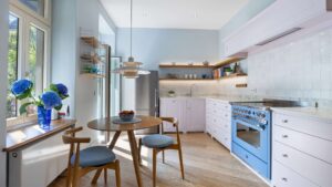 Kitchen with a round dining table by the window and a blue stove, additional view in an old building apartment in Haidhausen