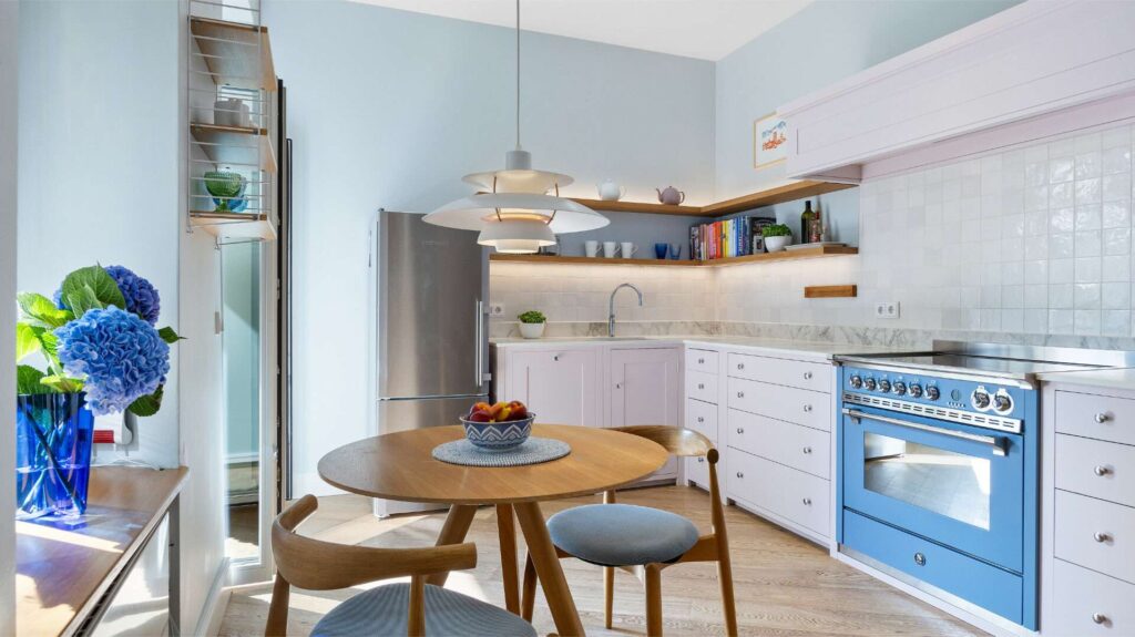Küche mit blauem Herd, Essplatz und Kühlschrank in einer Altbauwohnung in München-Haidhausen