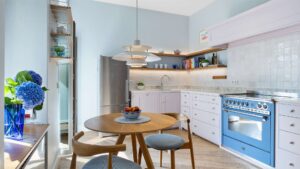 Kitchen with a blue stove, dining area, and refrigerator in an old building apartment in Munich-Haidhausen