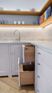 Kitchenette with open wooden shelves and sink in an old building apartment in Munich-Haidhausen