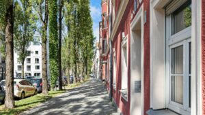 Tree-lined historic street with red-plastered facades in the Munich district of Haidhausen
